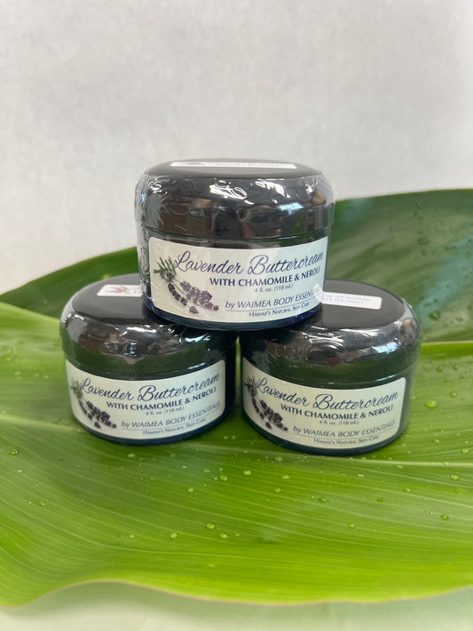 Three jars of Lavender Buttercream with Chamomile & Neroli stacked on a green leaf